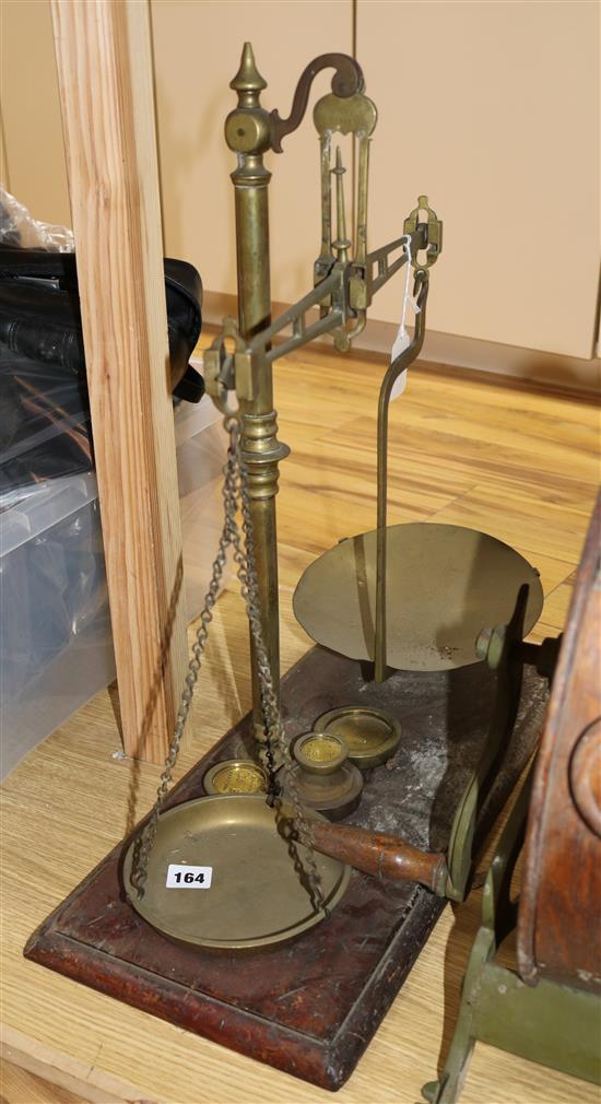 A brass balance, with turned central stem and two pans, with brass weights